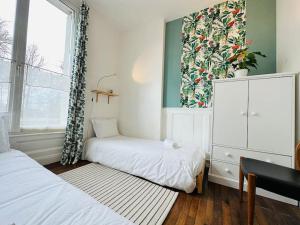 mała sypialnia z dwoma łóżkami i oknem w obiekcie Le jardin secret - Jardin/Loire w Tours