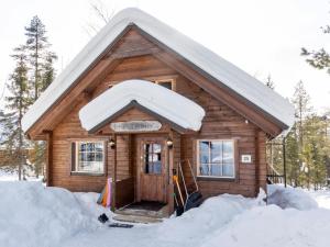 ルオストにあるHoliday Home Mervinrinne by Interhomeの屋根に雪が積もる小さな木造キャビン