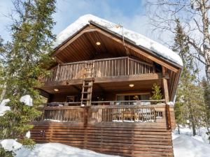a log cabin with snow on the roof at Holiday Home Mervinrinne by Interhome in Luosto
