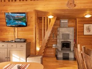 a living room with a fireplace and a television in a log cabin at Holiday Home Mervinrinne by Interhome in Luosto
