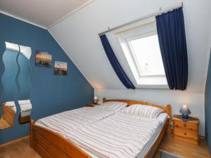 ドゥネンにあるApartment Vinnenhuis-1 by Interhomeのベッドルーム1室(青い壁のベッド1台、窓付)