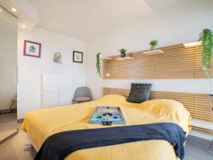 een slaapkamer met een groot bed en een gele deken bij Apartment Le Beaupré-21 by Interhome in Canet-en-Roussillon