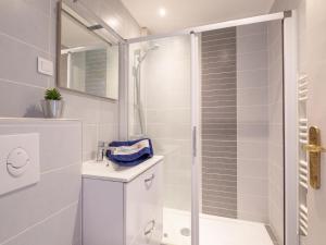 uma casa de banho branca com um chuveiro e um lavatório. em Apartment Le Méditerranée-1 by Interhome em Fréjus