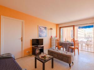 uma sala de estar com um sofá e uma mesa em Apartment Le Méditerranée-1 by Interhome em Fréjus