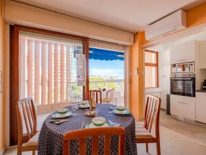 uma sala de jantar com mesa e cadeiras e uma grande janela em Apartment Le Méditerranée-1 by Interhome em Fréjus