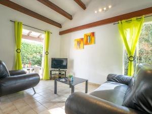 a living room with two couches and a tv at Holiday Home Les Aloès by Interhome in Sainte-Marie-la-Mer