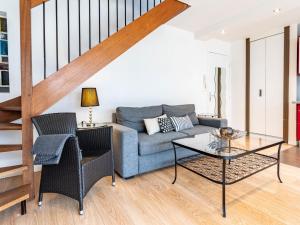 a living room with a couch and a table at Apartment Les Cigognes by Interhome in Deauville