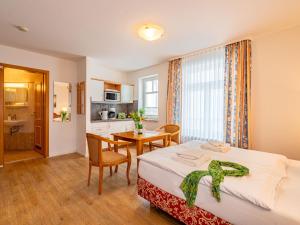 a bedroom with a bed and a table and a kitchen at Apartment Stolzenfels-1 by Interhome in Ostseebad Sellin