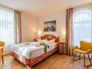 a hotel room with a bed and a chair at Apartment Stolzenfels-1 by Interhome in Ostseebad Sellin