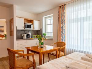 a room with a table and chairs and a kitchen at Apartment Stolzenfels-1 by Interhome in Ostseebad Sellin