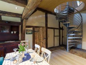 ein Esszimmer mit einem Tisch und einer Wendeltreppe in der Unterkunft Holiday Home Dat Litsche Hus-3 by Interhome 
