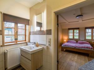 a bathroom with a sink and a bedroom with a bed at Apartment Dat Litsche Hus-1 by Interhome in Ober Ochtenhausen