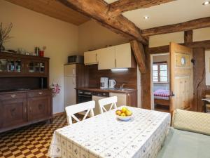 a kitchen with a table with a bowl of fruit on it at Apartment Dat Litsche Hus-1 by Interhome in Ober Ochtenhausen