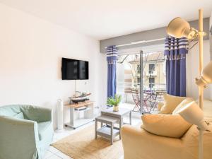 Una sala de estar con un sofá y un televisor. en Apartment Le Palma-2 by Interhome, en Arcachon
