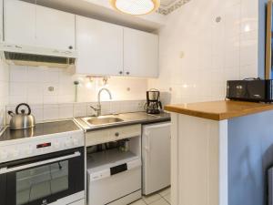 Una cocina con gabinetes blancos y un fregadero. en Apartment Le Palma-2 by Interhome, en Arcachon