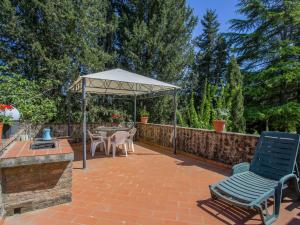 a patio with a table and chairs and an umbrella at Apartment Fattoria Petraglia - Terrazza by Interhome in Monteriggioni