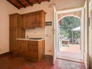 a kitchen with wooden cabinets and an open door at Apartment Fattoria Petraglia - Terrazza by Interhome in Monteriggioni