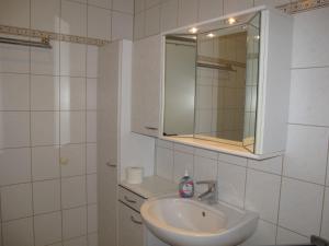 a white bathroom with a sink and a mirror at Apartment Gollwitzer Park - Insel Poel-6 by Interhome in Gollwitz