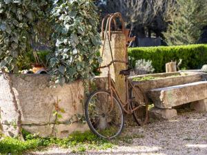 un vieux vélo garé à côté d'un mur de pierre dans l'établissement Holiday Home Mas de la Gourmette by Interhome, à Châteaurenard