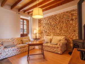 una sala de estar con 2 sofás y una pared de piedra. en Holiday Home Can Xerret by Interhome, en Sencelles