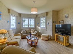 a living room with a couch and a tv at Apartment Le Moulin by Interhome in Saint-Philibert