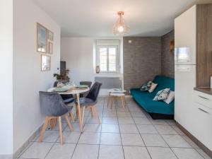a living room with a table and a couch at Holiday Home L'oyat by Interhome in Pirou