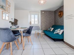 a living room with a blue couch and a table at Holiday Home L'oyat by Interhome in Pirou
