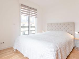 um quarto branco com uma cama grande e uma janela em Apartment Les Arts-1 by Interhome em Deauville