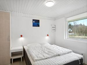een witte slaapkamer met een bed en een raam bij Holiday Home Eliasine - 200m to the inlet in The Liim Fiord by Interhome in Øster Assels