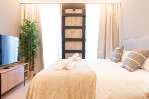 un dormitorio con una cama con dos animales de peluche en Old Town Apartments by Staynnapartments, en Bilbao