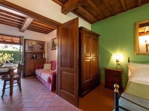 ein Schlafzimmer mit grünen Wänden, einem Bett und einem Tisch in der Unterkunft Holiday Home Lavanda by Interhome in La Pesta