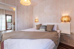 sypialnia z dużym białym łóżkiem z 2 lampami w obiekcie Magia Mazur - Domy Wakacyjne w mieście Mikołajki