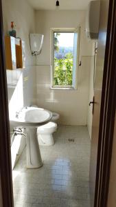 a bathroom with a toilet and a sink and a window at Villa Bianca in Ioppolo