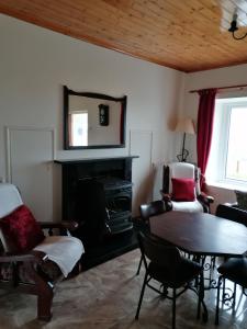 a living room with a table and chairs and a mirror at Atlantic Way Farmhouse in Lahinch