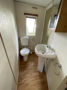 a small bathroom with a toilet and a sink at Charmant Mobile Home en foret in Braize