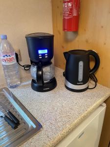 a coffee maker sitting on a counter next to a water bottle at Charmant Mobile Home en foret in Braize