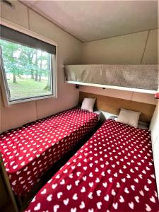 two beds in a small room with a window at Charmant Mobile Home en foret in Braize