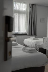 a row of beds in a room with a window at Hotel de la Bourse in Maastricht