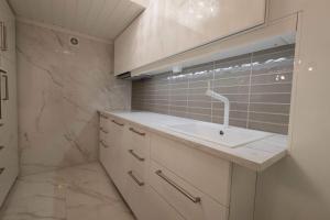 een witte badkamer met een wastafel en een douche bij Koselig leilighet i rolig boligfelt in Gol