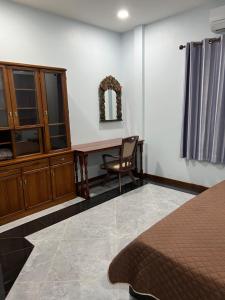 een slaapkamer met een bed, een bureau en een stoel bij New Home บ้านเดี่ยว สร้างใหม่ ใกล้ทะเล ใจกลางเมืองระยอง in Rayong