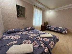 a bedroom with a large bed with a blue blanket at Kutaisi City Heart Apartment in Kutaisi