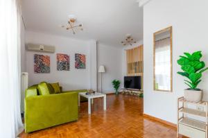 - un salon avec un canapé vert et une table dans l'établissement Penthouse 2Bd apartment in the heart of Koukaki, à Athènes