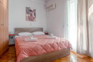 - une chambre avec un lit et une couette rose dans l'établissement Penthouse 2Bd apartment in the heart of Koukaki, à Athènes