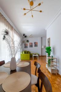 - un salon avec une table, des chaises et un canapé vert dans l'établissement Penthouse 2Bd apartment in the heart of Koukaki, à Athènes