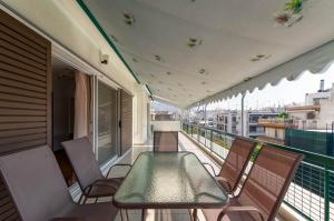 - un balcon avec une table et des chaises dans un bâtiment dans l'établissement Penthouse 2Bd apartment in the heart of Koukaki, à Athènes
