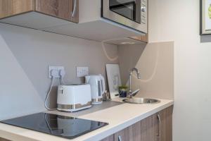 a kitchen counter with a coffee maker and a sink at Modern Studio Apartment with Free Parking in Wolverhampton 5min walk to City Centre in Wolverhampton