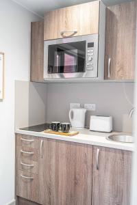 a kitchen with a counter top with a microwave at Modern Studio Apartment with Free Parking in Wolverhampton 5min walk to City Centre in Wolverhampton