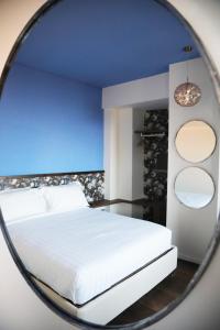 Un dormitorio con una cama blanca en un espejo en Le Dimore del Centrale, en Macerata