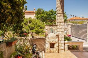 a garden with a stone oven in a yard at Apartments Jadranka in Medulin