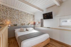 a bedroom with a bed and a tv on the wall at Loft 35 - private parking in Quartu SantʼElena